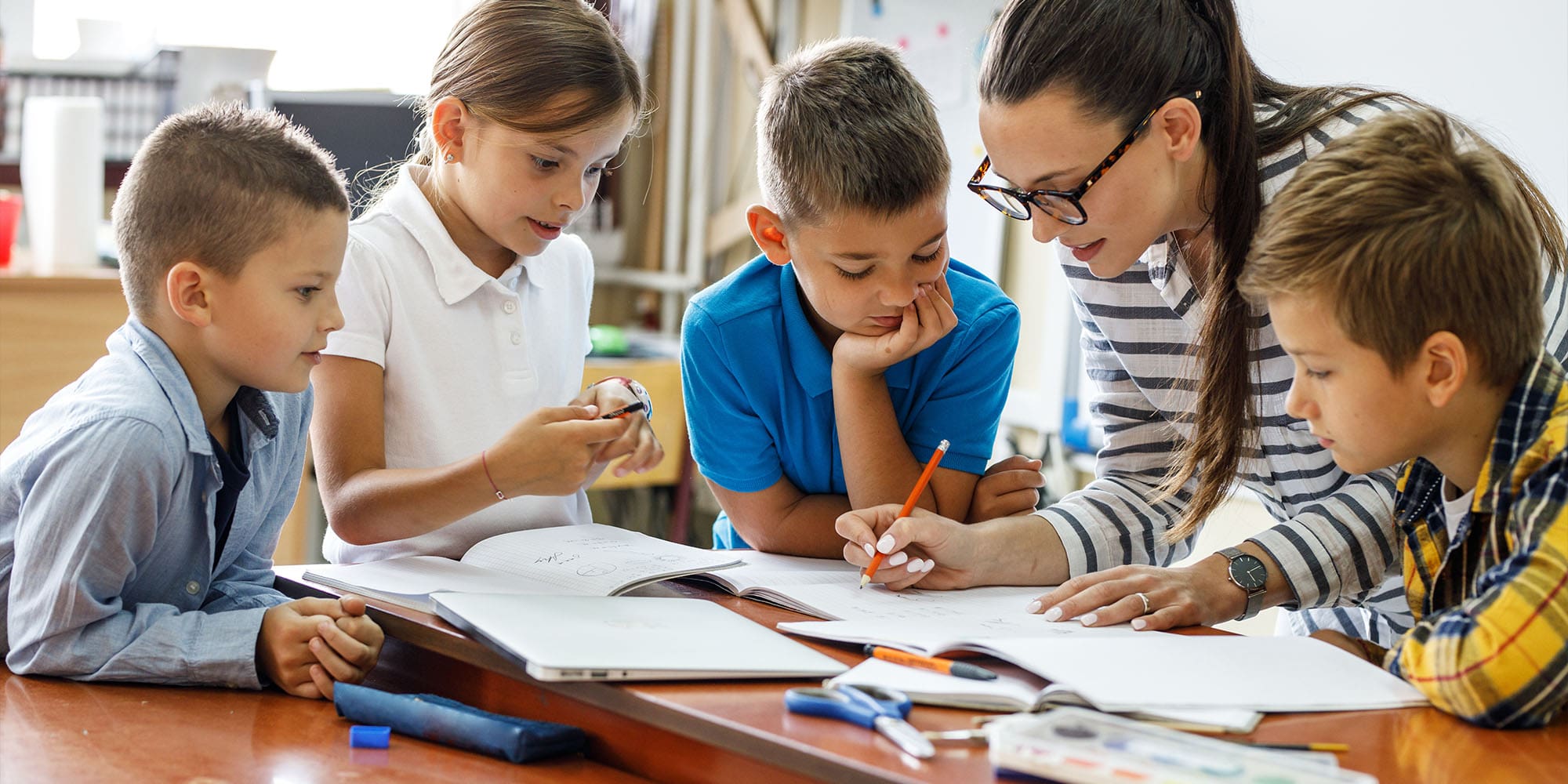 Teacher working with four primary school students