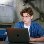 young male student in front of a laptop