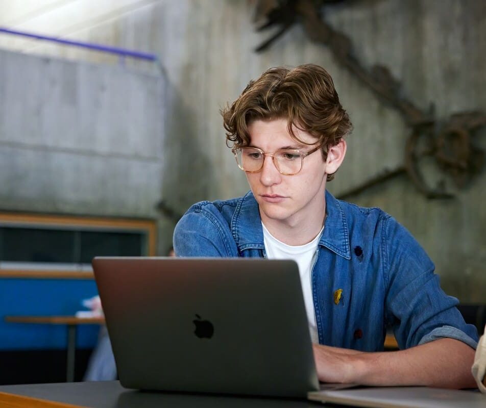 young male student in front of a laptop