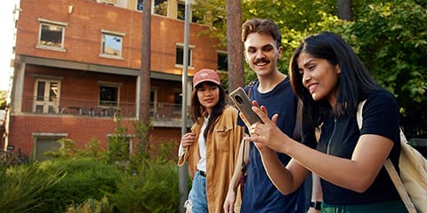 student walking on campus with mobile phone